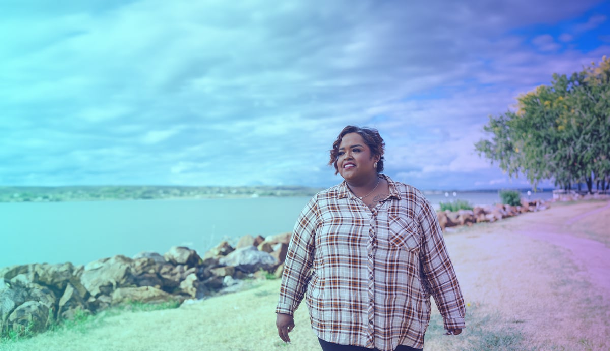 Female standing in front of lake smiling